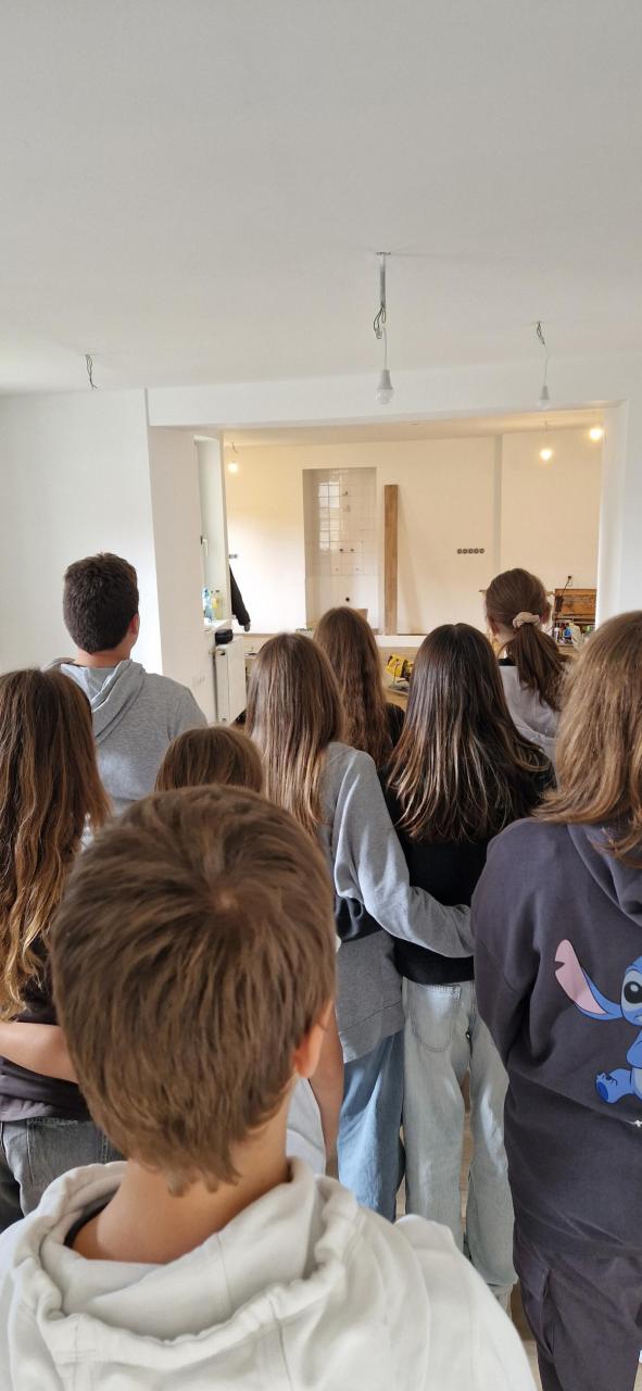 Eine Klasse der Mittelschule besucht die Bibliothek im Rohzustand und entscheidet, wo das Jugendregal stehen wird. Danach werden Bücher beim Bookcasting im Gemeindesaal bewertet.